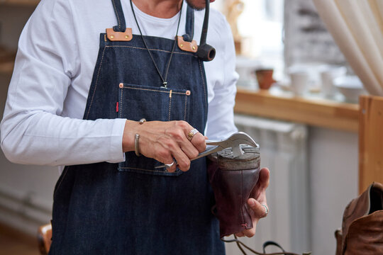shoemaker workshop for making shows artisan handmade manufacturing leather shoes, restoration. shoe manufacture business for traditional vintage shoe making. cropped man in apron