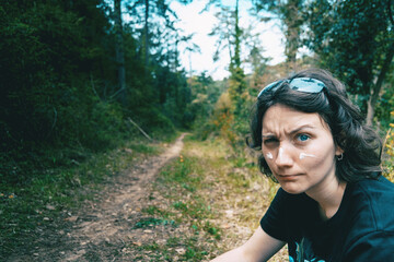 Portrait of a blue-eyed girl looking at camera and making fun with sunscreen on her face