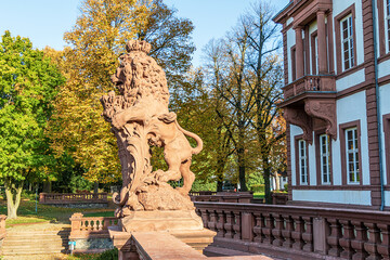 Fototapeta na wymiar Lion sculpture in English landscaped park of Phillipsruhe Castle on a sunny October day in Hanau, Hesse, Germany