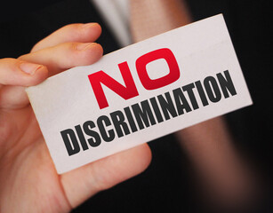 No discrimination words on a card in businessman hand. Social concept against racial and gender...