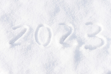 2023 written on the snow. Happy new year. Sunny winter day.