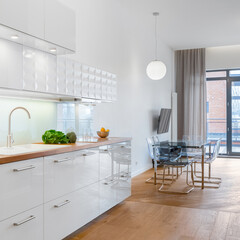 Stylish white kitchen with dining table