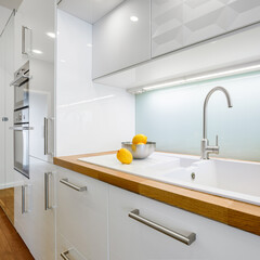 Fototapeta na wymiar White kitchen sink in wooden countertop