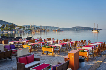 Cute chairs and table on the beach at seaside restaurant in Bodrum