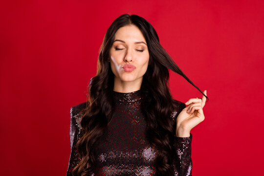 Photo of pretty wavy hairdo person closed eyes kiss lips finger play with hair tail isolated on red color background