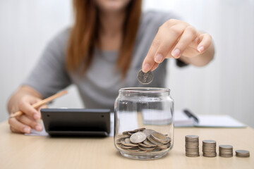business woman holding coins putting in glass. concept saving money for finance accounting.