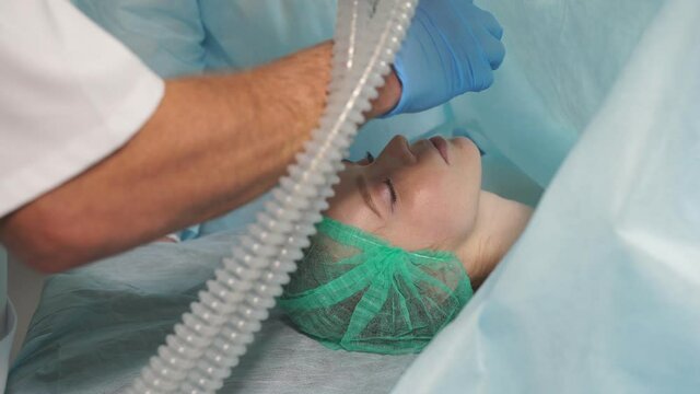 Medical doctor giving anesthesia to young girl in hospital. Medical professional working in hospital. Anesthesiologist at work.
