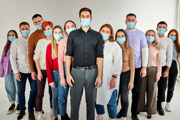 Obraz premium people with in protective masks from Coronavirus infections, Covid-19. leader man with other millennials behind him with serious eyes looking into the camera