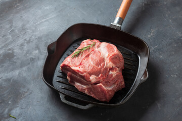 piece of raw meat in a frying pan, top view