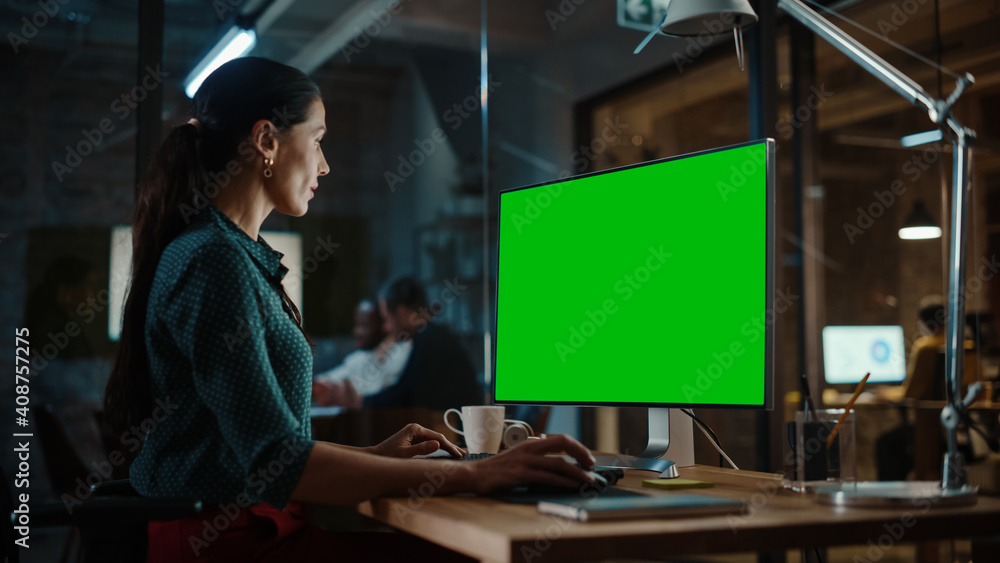 Aufkleber Middle Aged Multiethnic Specialist Working on Desktop Computer with Green Screen Mock Up Display in Busy Creative Office. Beautiful Diverse Female Manager in Green Polka Dot Blouse.