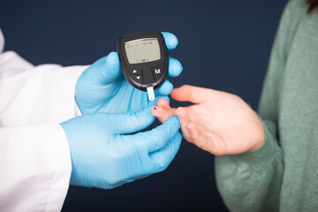 Doctor making blood sugar test in clinic for diabetes.