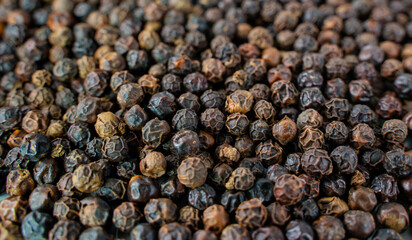 Black pepper grains as background close up.