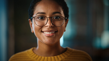 Close Up Portrait of a Young Non-Binary Latina with Short Dark Hair and Glasses Posing for Camera in Creative Office. Beautiful Diverse Multiethnic Hispanic Female is Happy and Smiling. - Powered by Adobe