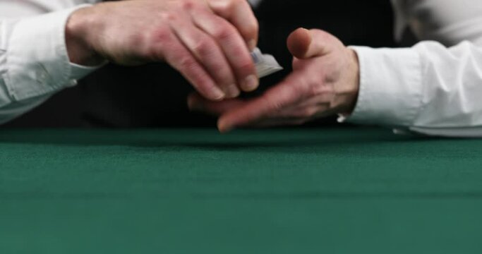 Professional casino croupier shuffling and dealing cards, gambling, close-up