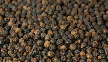 Black pepper grains as background close up.