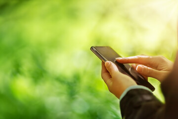 Young woman on nature using her smartphone