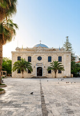 Popular place of interest among the tourists - Greek Orthodox Cathedral of Agios Minas in Heraklion, Crete with its square and palms. 