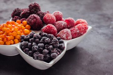 Close up of frozen mixed fruits and berries on a black table  Healthy food vitamins snack dessert