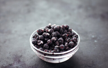 Fototapeta na wymiar Close up of frozen blueberries on a black table