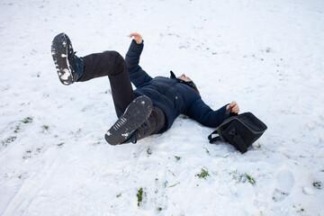 A man falls in the snow. The man slipped and was injured. Falling on ice. Winter. Fracture, bruise,...