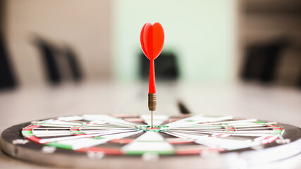 The dart board has an arrow thrown into the center of the shooting target for business targeting.