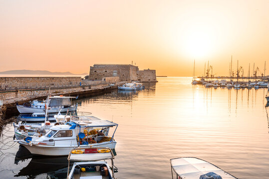 Old port of Heraklion, morning view to the traditional boats and well known fortress Koulesy at the background.  