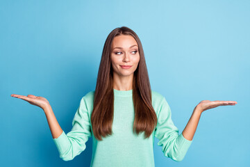 Portrait of nice curious cheery brown-haired girl holding on palms copy space choosing options...