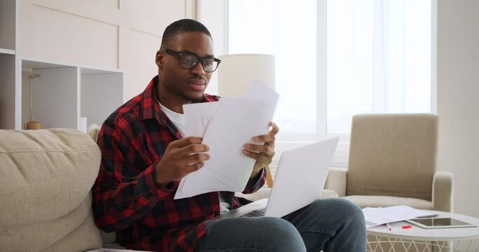 Man feeling relief on founding misplaced document while working on laptop