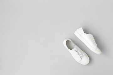 White sneakers on gray background. Overhead shot, flat lay, top view. Space for text.	