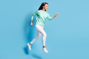Fototapeta premium Profile photo of shiny cute girl wear casual outfit jumping running hands fists isolated blue color background