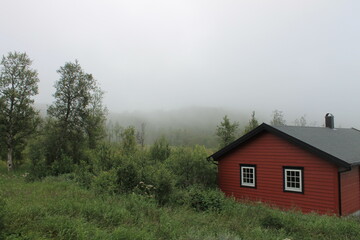 
Morning view of a house shrouded in fog in the mountains of Norway.