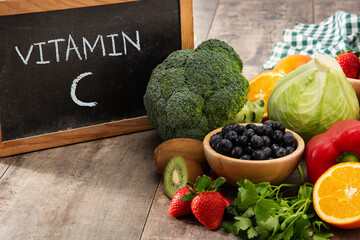 High in vitamin C food and blackboard on wooden table	
