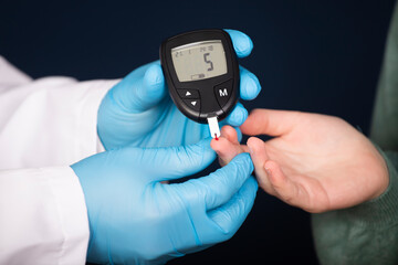 Doctor making blood sugar test in clinic for diabetes.