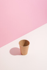 Trending colors. Design of paper cup on white table on pink background. Copy space - 408763634