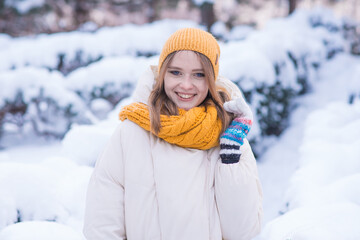Obraz premium Portrait of a happy smiling girl on a snowy winter day