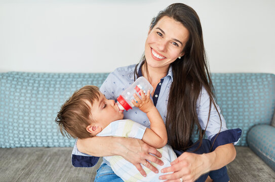 Mother Holds Toddler While Drinking Bottle Of Milk