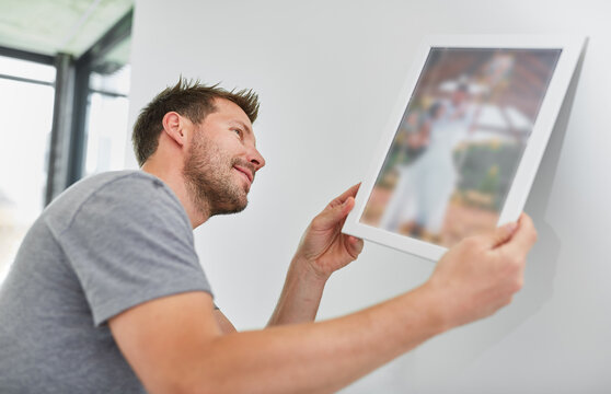 Man as a handyman when hanging up picture