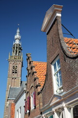 Colorful facades of historic houses in Edam, North Holland, Netherlands, with the Speeltoren (Carillon Tower) in the background