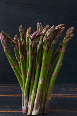 Fresh green asparagus bunch on black wooden background. Close up view