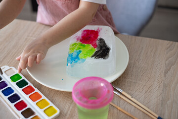 Obraz na płótnie Canvas Child painting an ice, sensory activity, DIY.