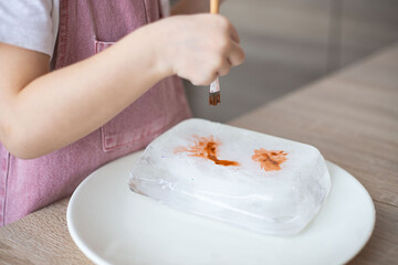 Child painting ice block, fantastic chilly sensory activity and art for preschoolers and toddlers.
