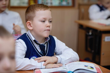 Schoolboy at the desk in the classroom
