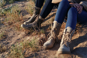 Male and female legs in army beige boots. Outdoor activities couples in the wilderness