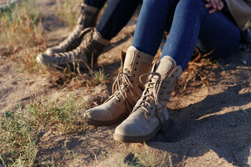 Female and male legs in army beige boots. Outdoor activities couples in the wilderness