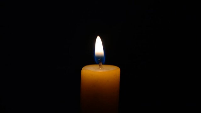 Close-up Single Candle Flame Isolated on Black Background