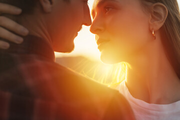 Close-up cropped portrait of a beautiful lovely couple enjoying each other on the sunset.