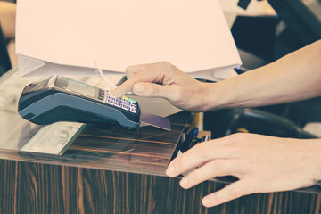 Shop cashier operating payment process with pos terminal and credit card. Cropped shot, closeup of...