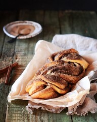 Cinnamon twisted loaf bread or babka on a dark wooden background, still life, rustic style