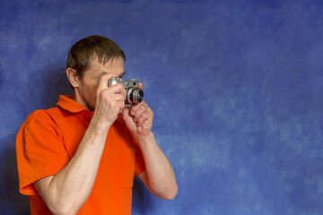 a European man with a film camera in his hands. Photographer with an analog camera and photographic...