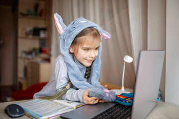 Distant education, online class meeting. Girl wearing funny hat for amusement during online lesson